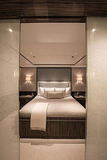 a bed with a white bed spread aboard M5 Yacht for Sale