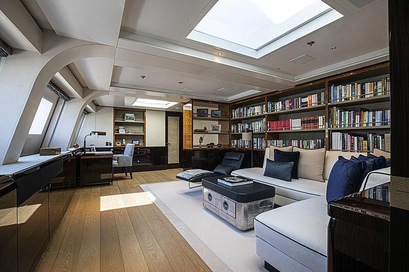 a room with a couch and a table and a bookcase aboard M5 Yacht for Sale