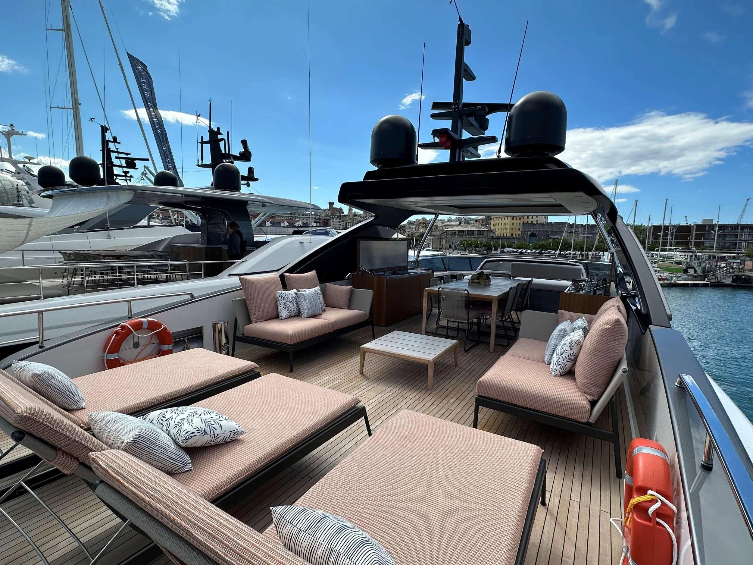 a deck with a couch and a large ship in the background aboard QUEEN MARTINA Yacht for Sale