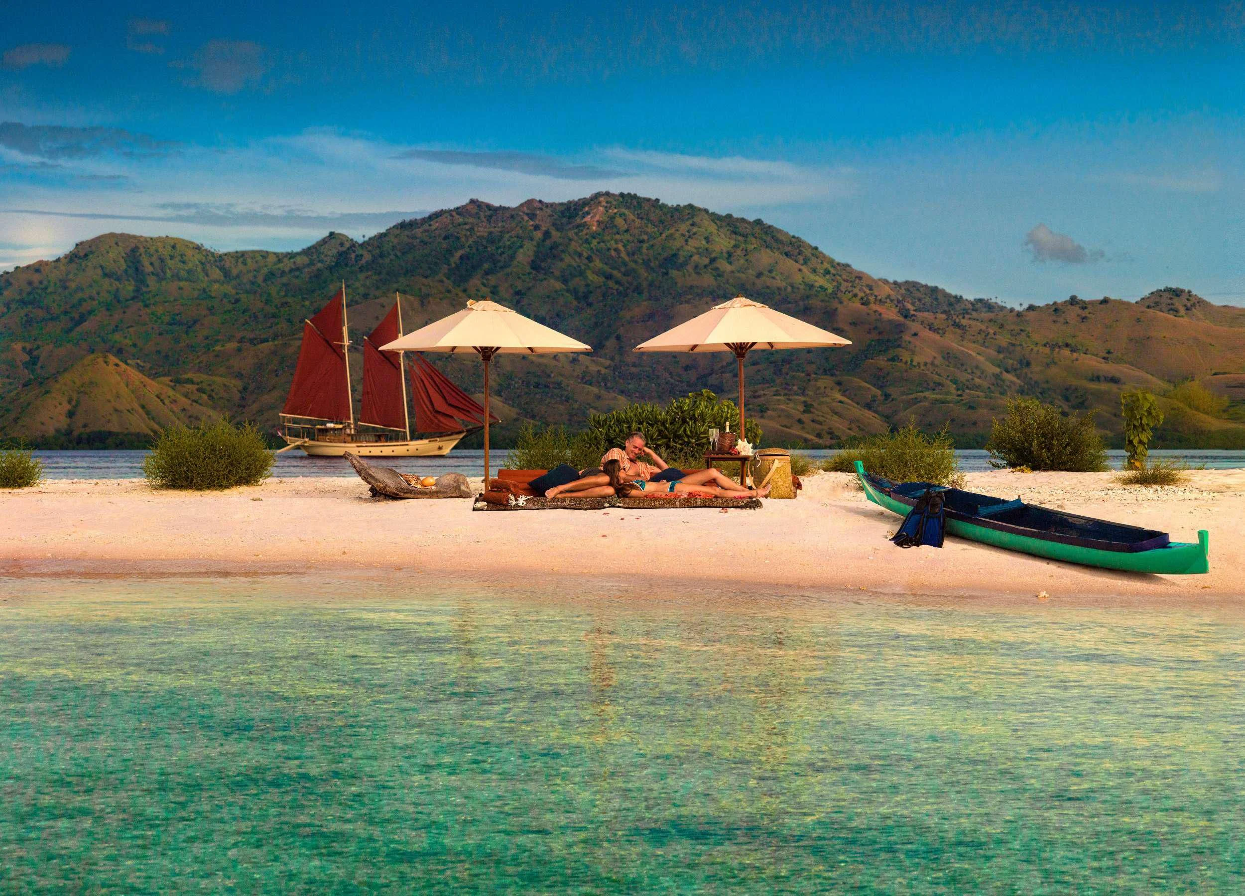 a beach with umbrellas and lounge chairs aboard SI DATU BUA Yacht for Sale