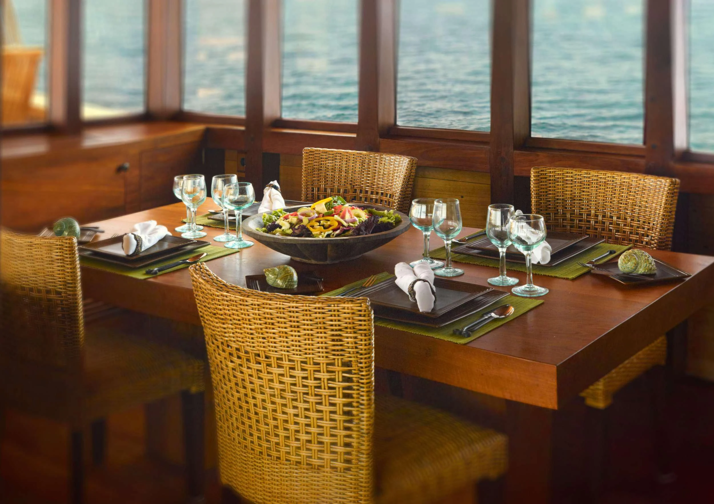 a table with food and wine glasses aboard SI DATU BUA Yacht for Sale