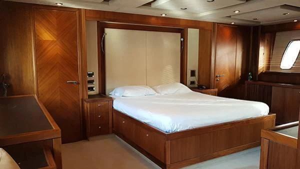 a room with a bed and desk aboard LAURA S Yacht for Sale