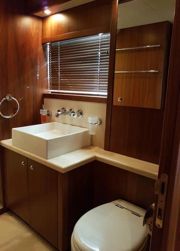 a bathroom with a toilet and a sink aboard LAURA S Yacht for Sale