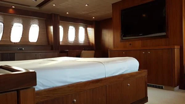 a room with a bed and a tv on the wall aboard LAURA S Yacht for Sale