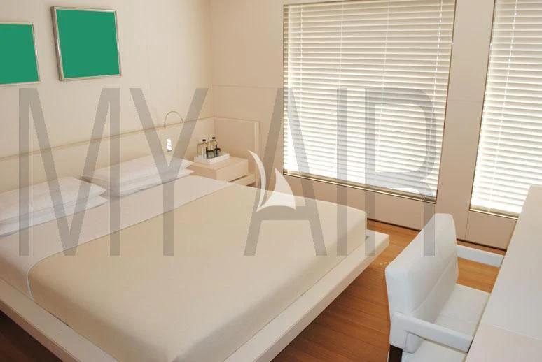 a room with a bed and a chair aboard AIR Yacht for Sale