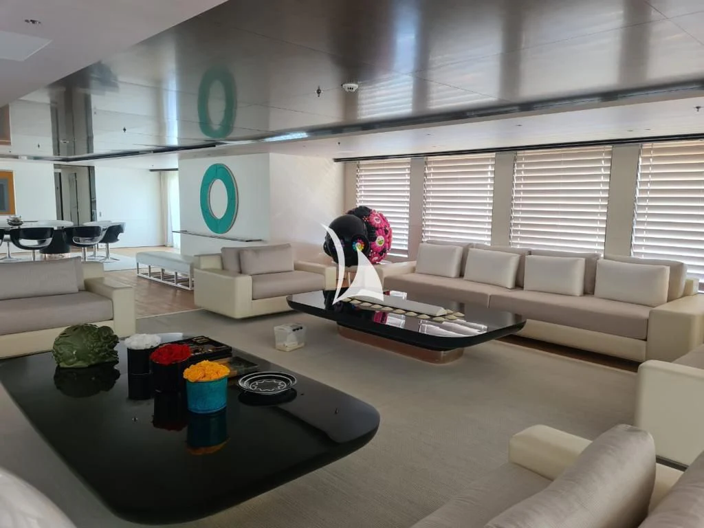 a person in a room with a table and a couch aboard AIR Yacht for Sale