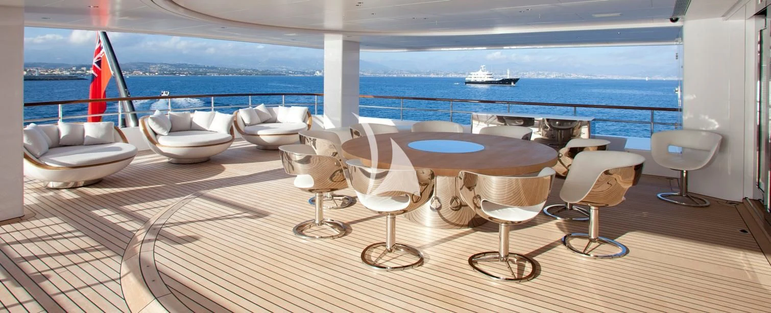a room with a table chairs and a flag on the wall aboard AIR Yacht for Sale