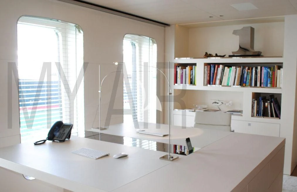 a desk with a computer and a book shelf aboard AIR Yacht for Sale