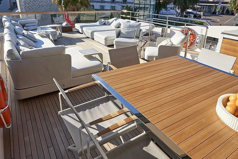 a deck with a table and chairs aboard GI1 Yacht for Sale
