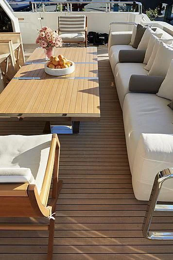 a wooden table with chairs and a bowl of fruit on it aboard GI1 Yacht for Sale