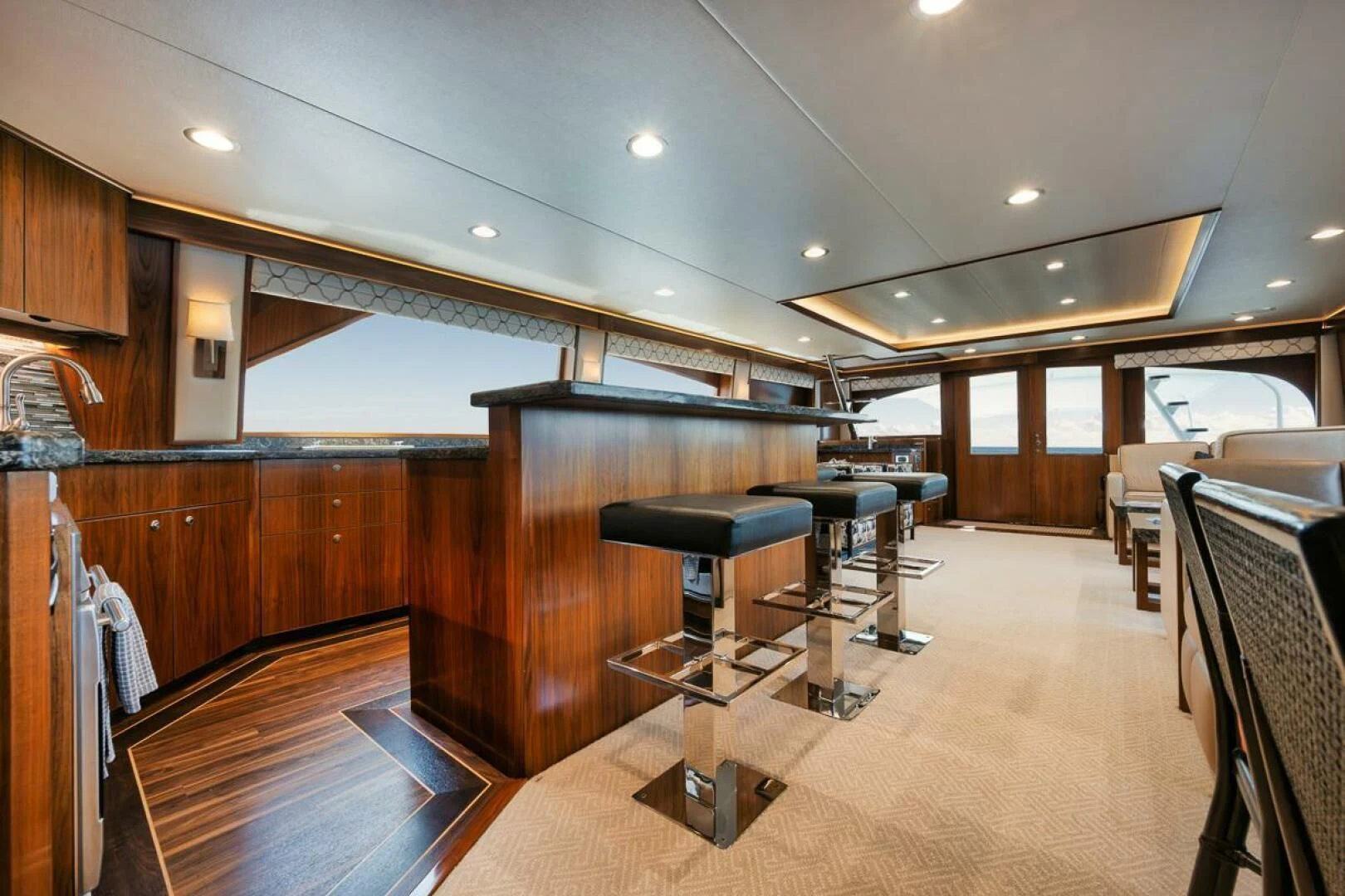 a large kitchen with a bar and bar stools aboard BELLA DONNA DI Yacht for Sale