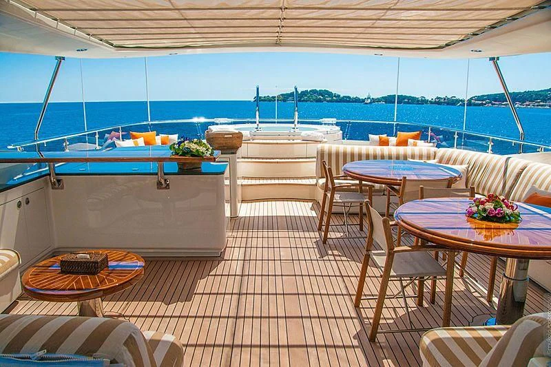 a patio with tables and chairs aboard GLORIA TERESA Yacht for Sale