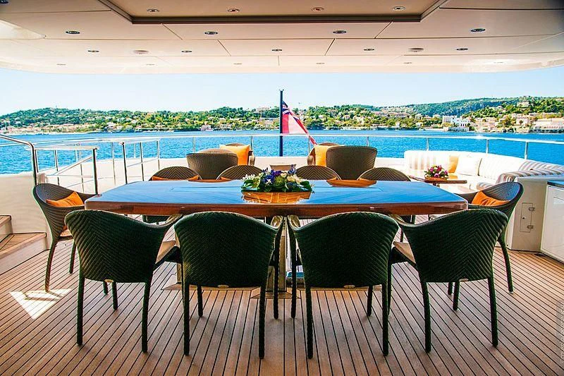 a table with chairs and a pool in the background aboard GLORIA TERESA Yacht for Sale