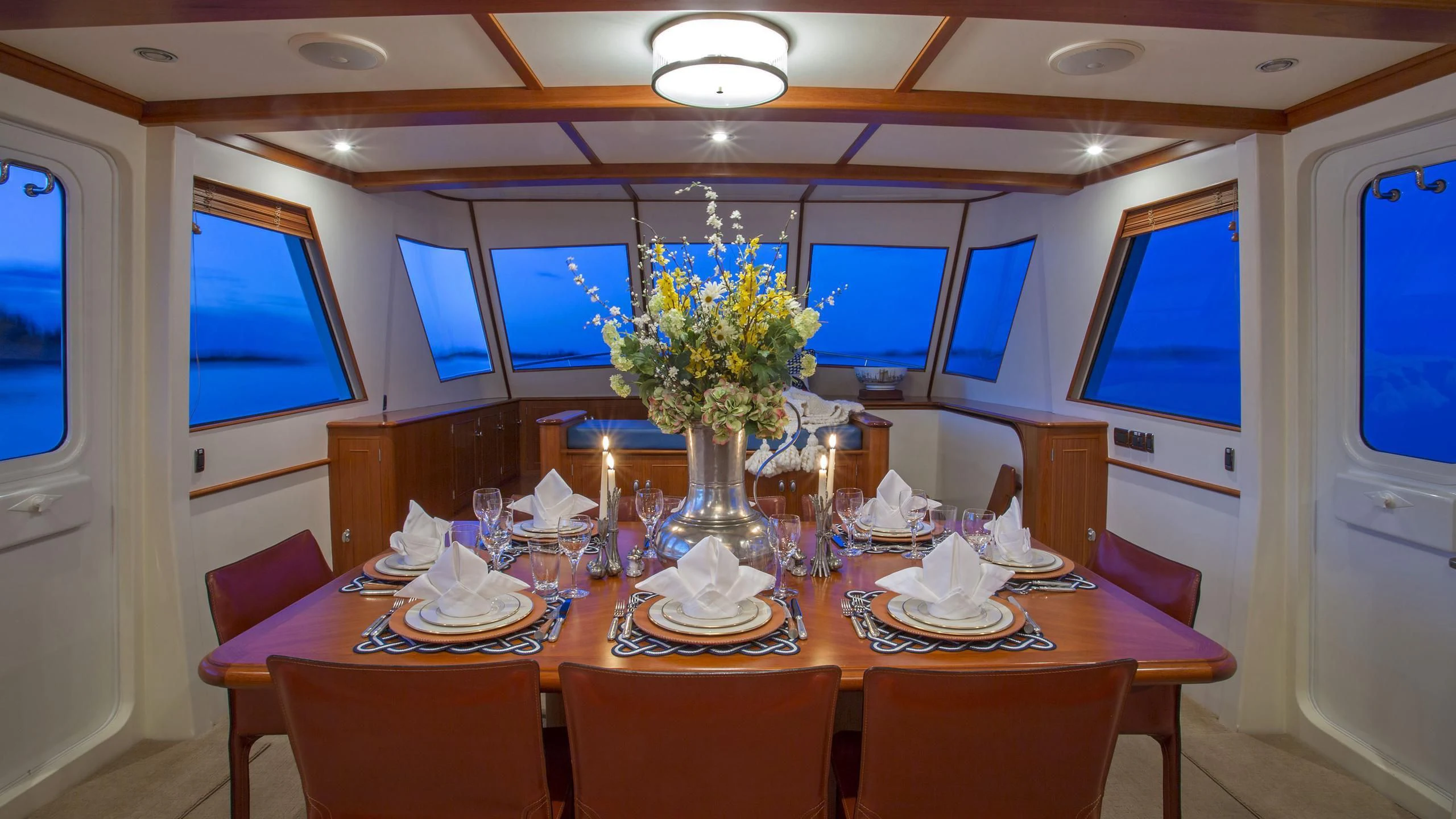 a dining table with a vase of flowers on it aboard SEA BOLD Yacht for Sale