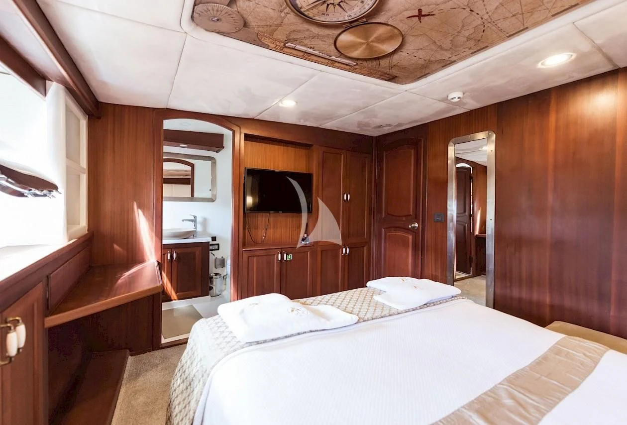 a bedroom with a bed and a television aboard VIRTUOSO Yacht for Sale