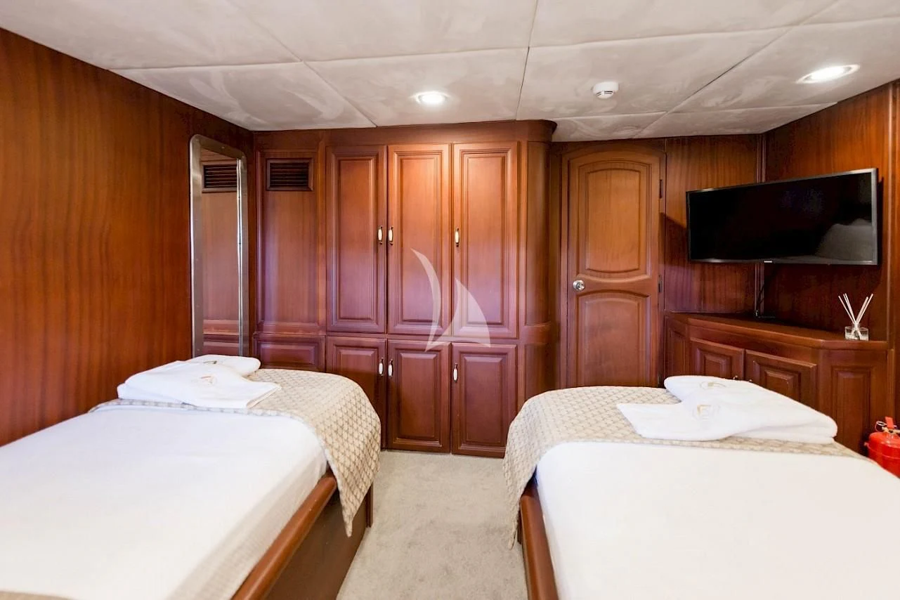 a room with a bed and a television aboard VIRTUOSO Yacht for Sale