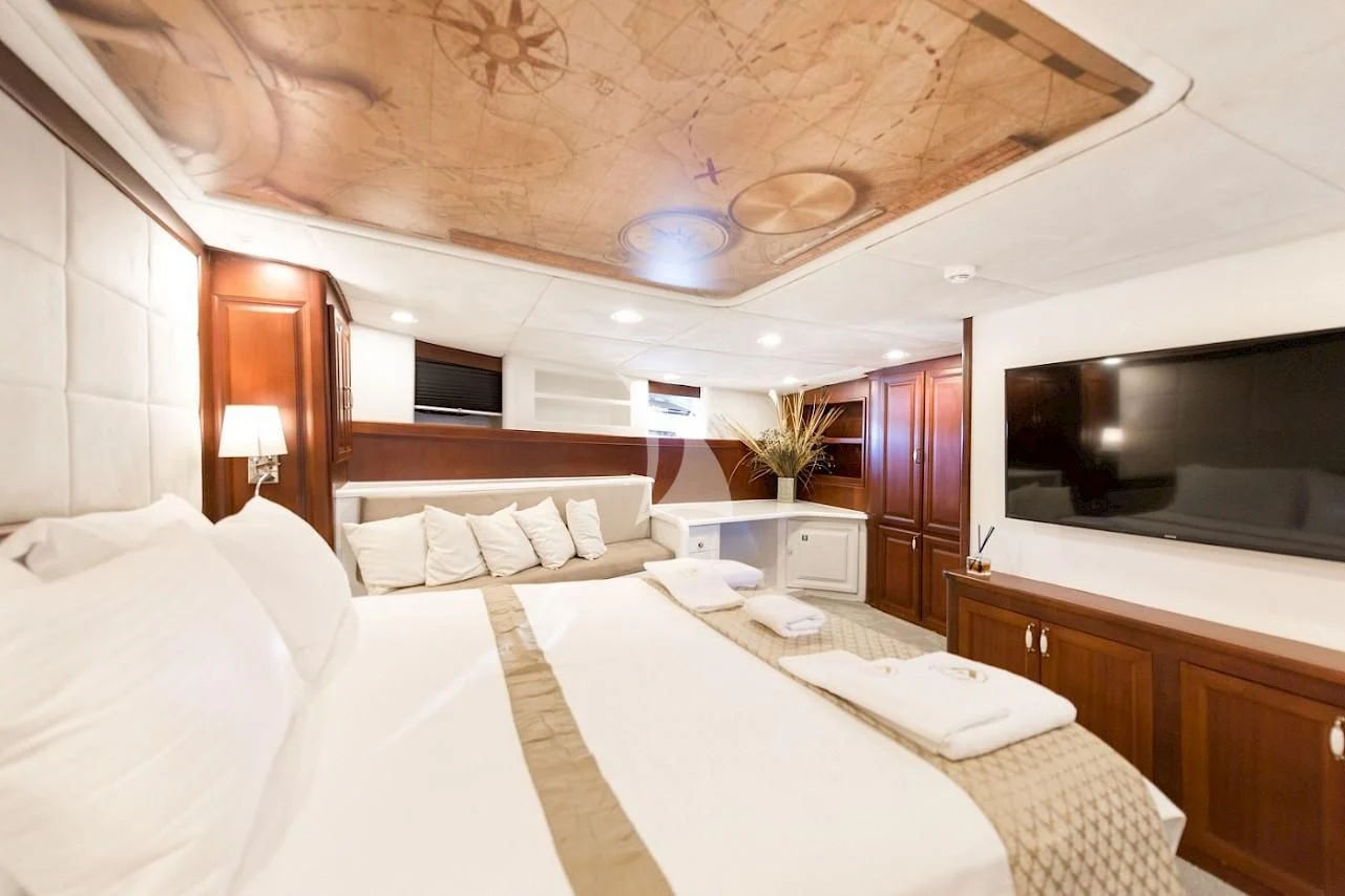 a room with a bed and a television aboard VIRTUOSO Yacht for Sale