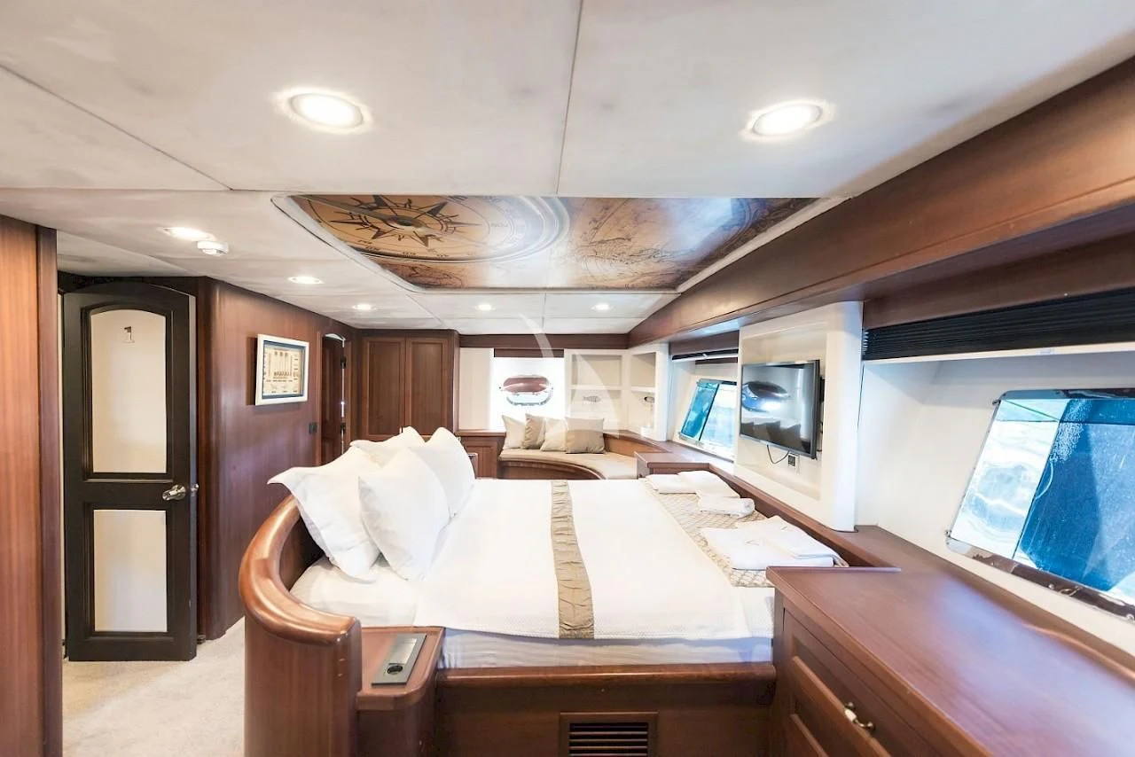 a bedroom with a bed and a desk aboard VIRTUOSO Yacht for Sale