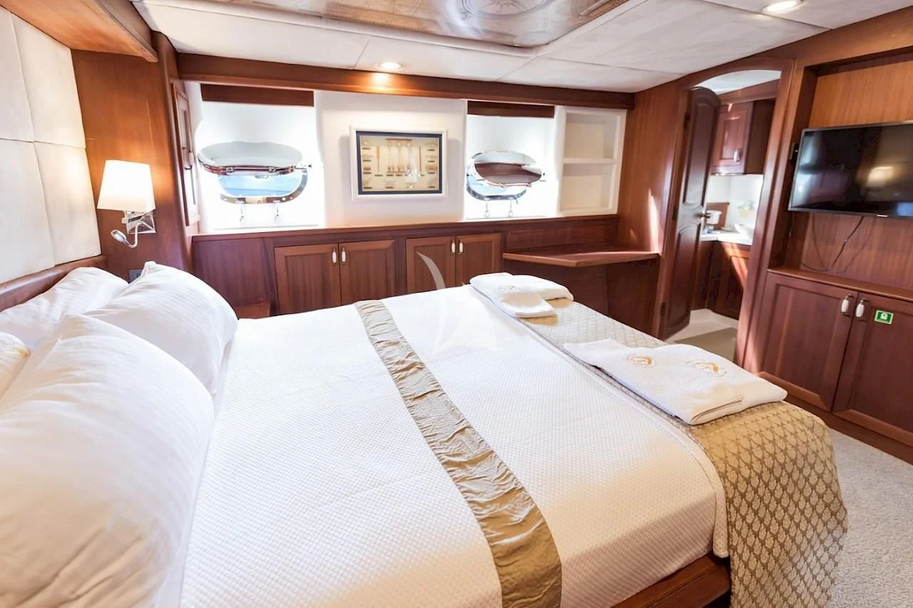 a room with a bed and a television aboard VIRTUOSO Yacht for Sale