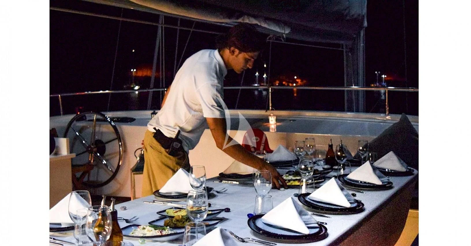 a man pouring wine into a glass aboard VIRTUOSO Yacht for Sale