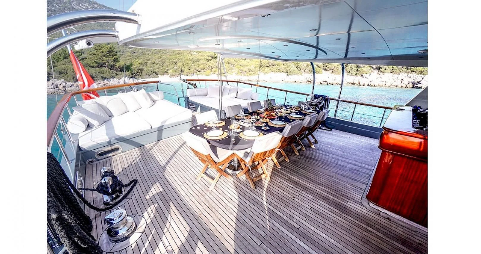 a deck with a table and chairs on it aboard VIRTUOSO Yacht for Sale
