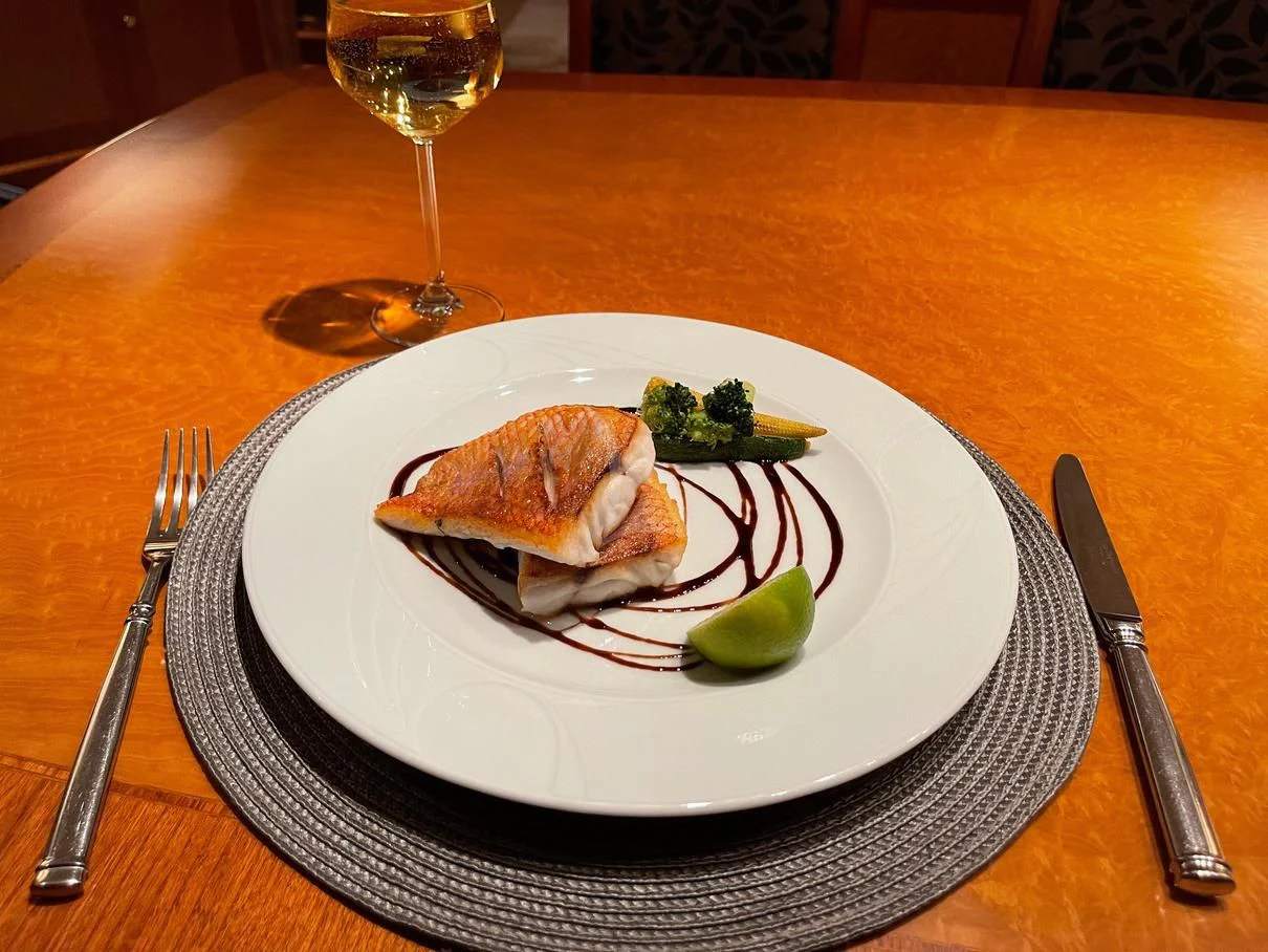 a plate of food and a glass of wine on a table aboard GALAKTIKA SKAY Yacht for Sale