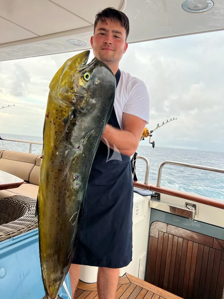 a man holding a fish aboard GALAKTIKA SKAY Yacht for Sale