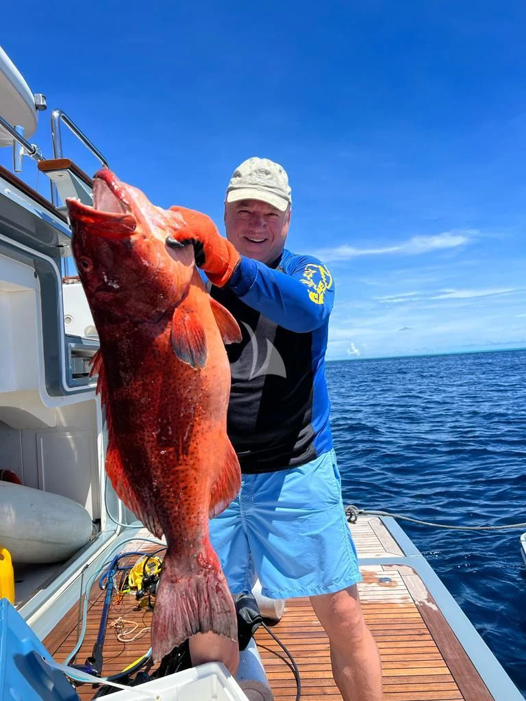 a man holding a fish aboard GALAKTIKA SKAY Yacht for Sale