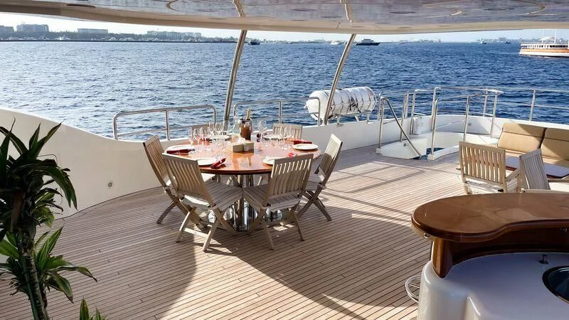 a table and chairs on a deck overlooking a body of water aboard GALAKTIKA SKAY Yacht for Sale
