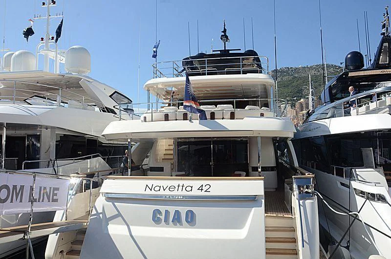 a group of boats docked with HMS M33 in the background aboard APRIL Yacht for Sale