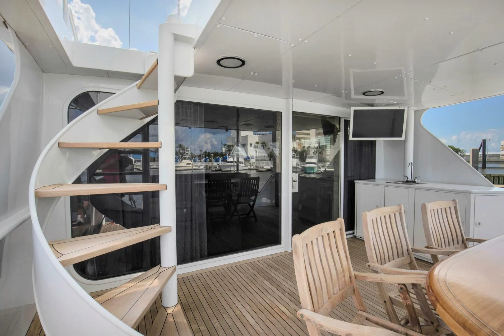 a room with a wood table and chairs and a tv on the wall aboard LADY P Yacht for Sale