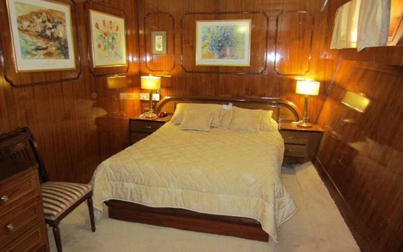 a bed with lamps on either side of it aboard ELIKI Yacht for Sale