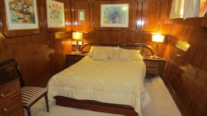 a bed with lamps on either side of it aboard ELIKI Yacht for Sale