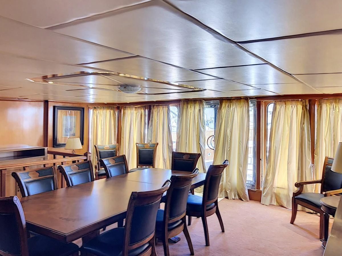 a large room with a table and chairs aboard ELIKI Yacht for Sale