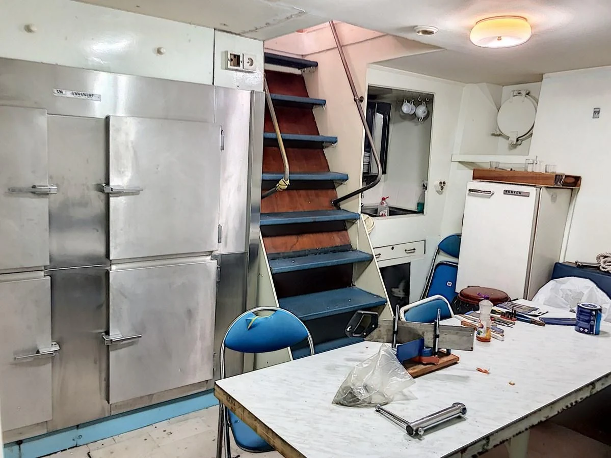 a room with a table and chairs aboard ELIKI Yacht for Sale