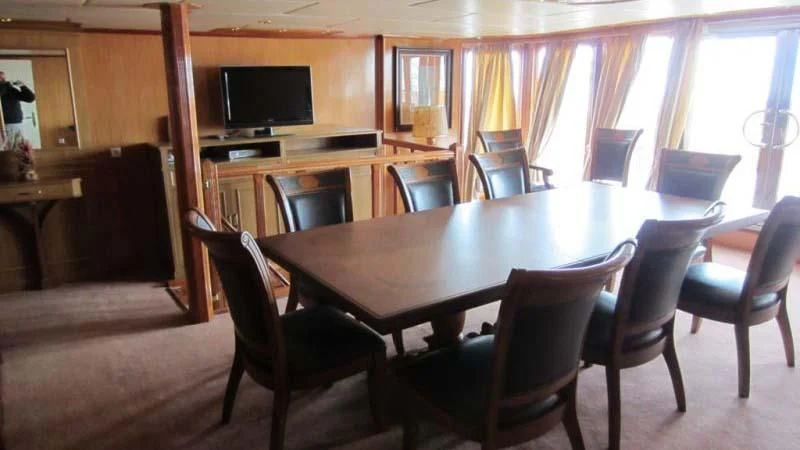 a room with a table and chairs aboard ELIKI Yacht for Sale
