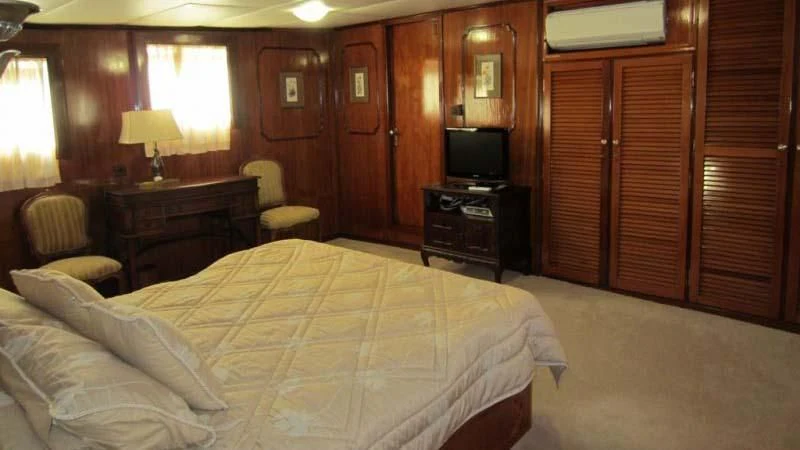 a hotel room with a bed and a television aboard ELIKI Yacht for Sale