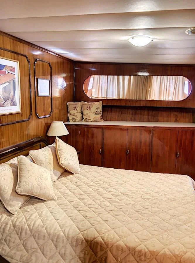 a bed with a yellow comforter aboard ELIKI Yacht for Sale