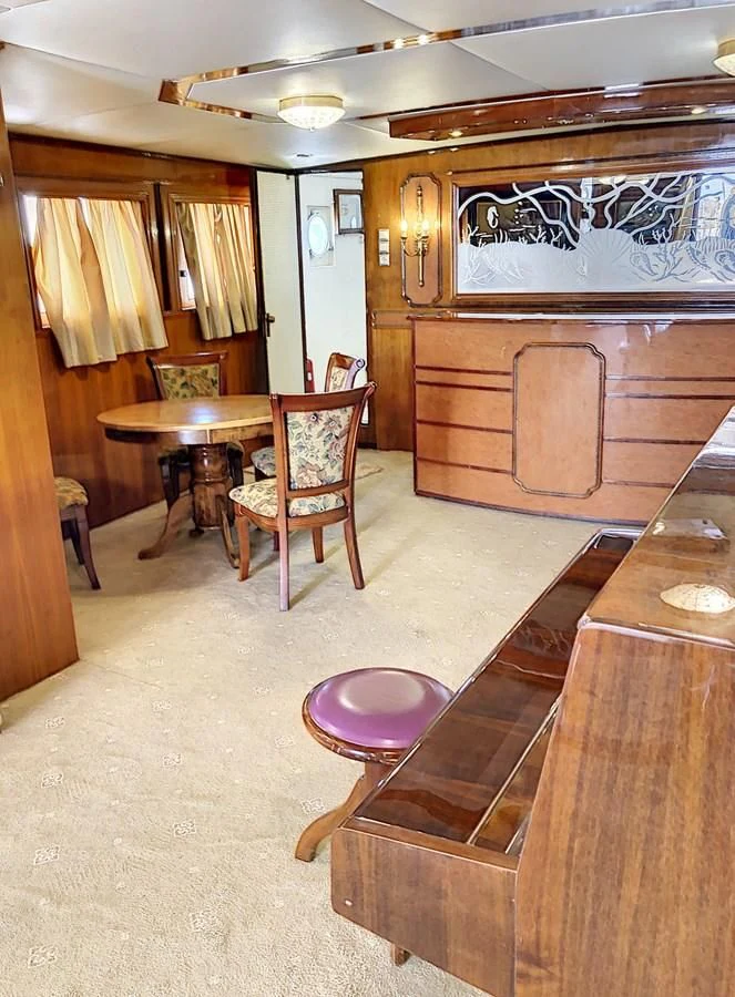 a room with a table and chairs aboard ELIKI Yacht for Sale