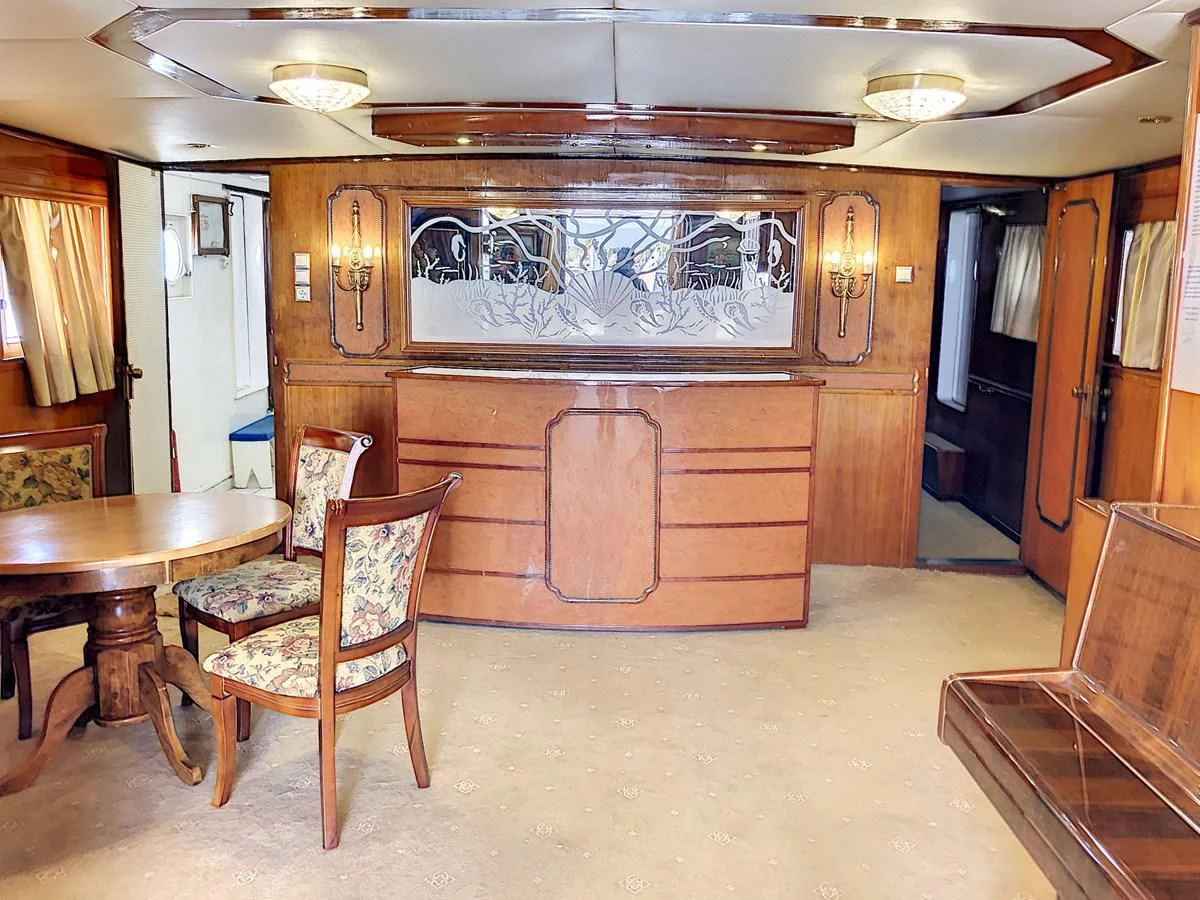 a room with a table and chairs aboard ELIKI Yacht for Sale