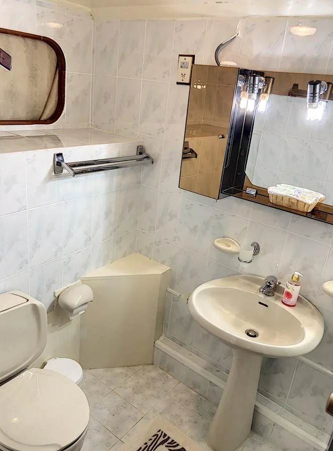 a bathroom with a sink toilet and a mirror aboard ELIKI Yacht for Sale
