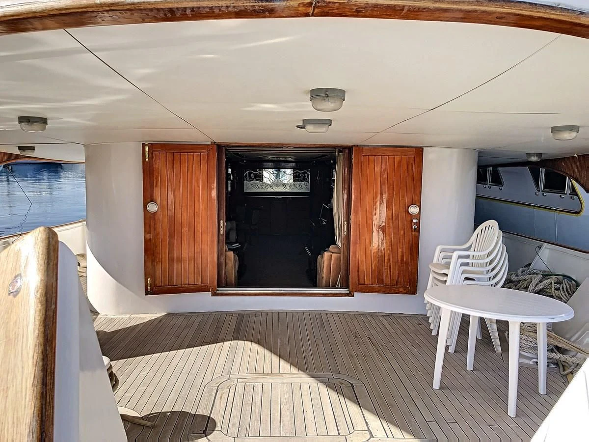 a room with a bed and chairs aboard ELIKI Yacht for Sale