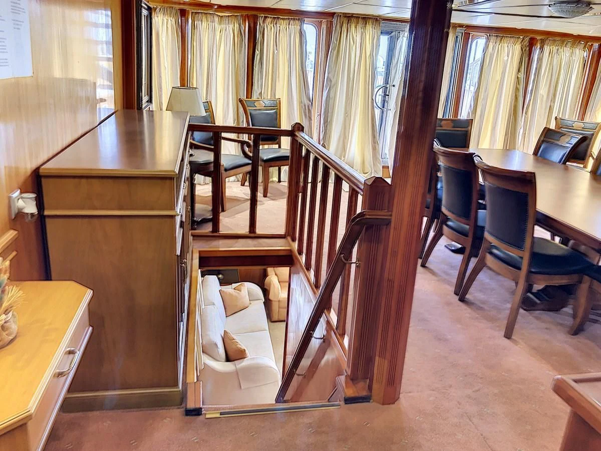 a room with a table chairs and a window aboard ELIKI Yacht for Sale