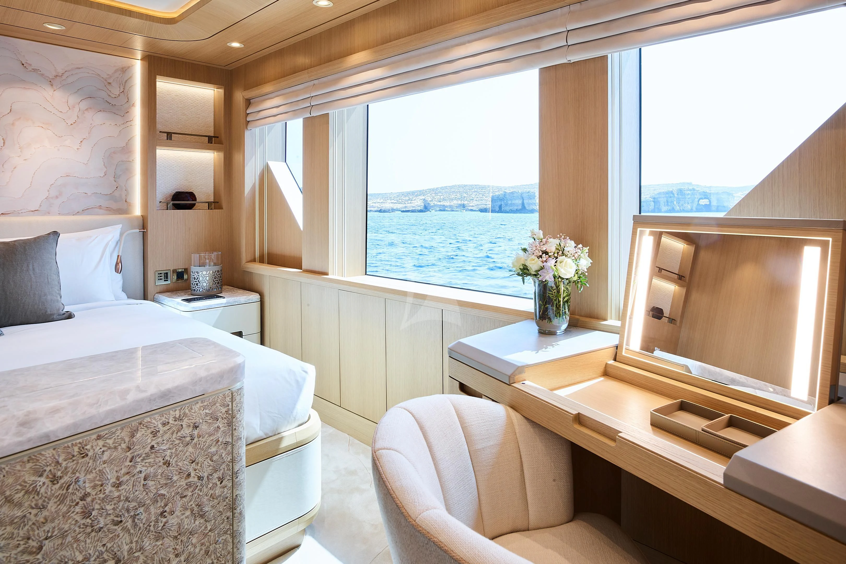 a room with a bed and a table and a window aboard COME TOGETHER Yacht for Charter