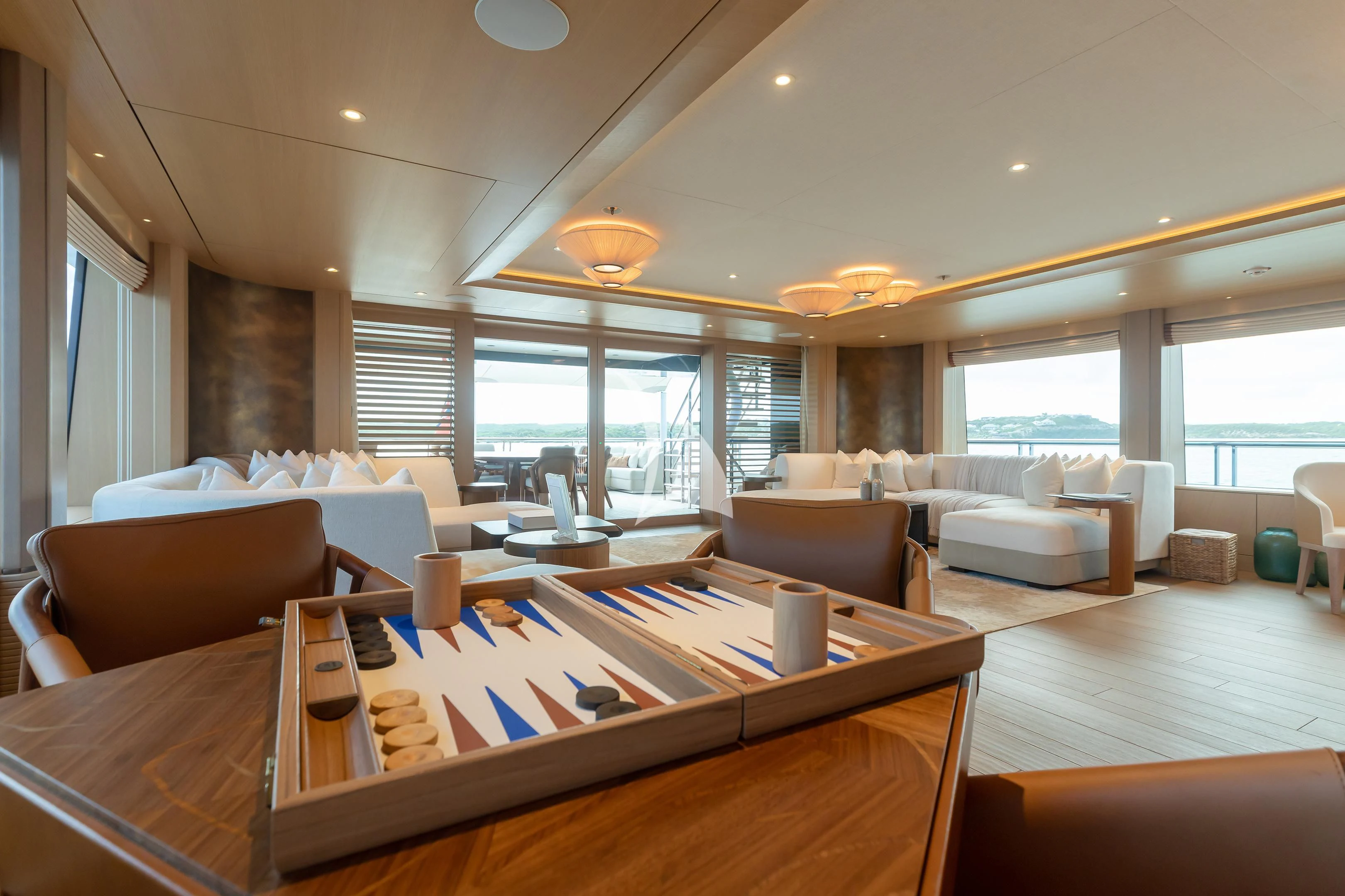 a large living room with a large table and chairs aboard COME TOGETHER Yacht for Charter