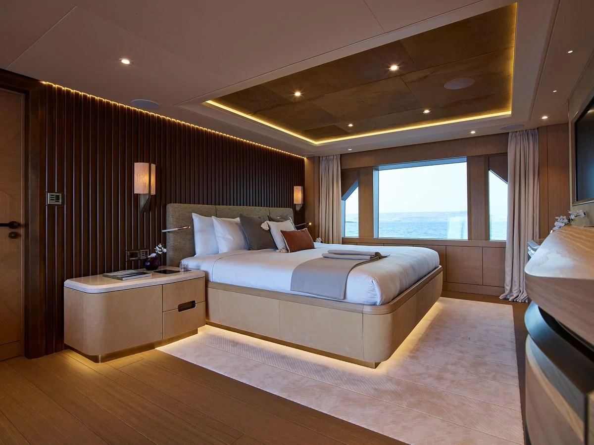a bedroom with a bed and a window aboard COME TOGETHER Yacht for Charter