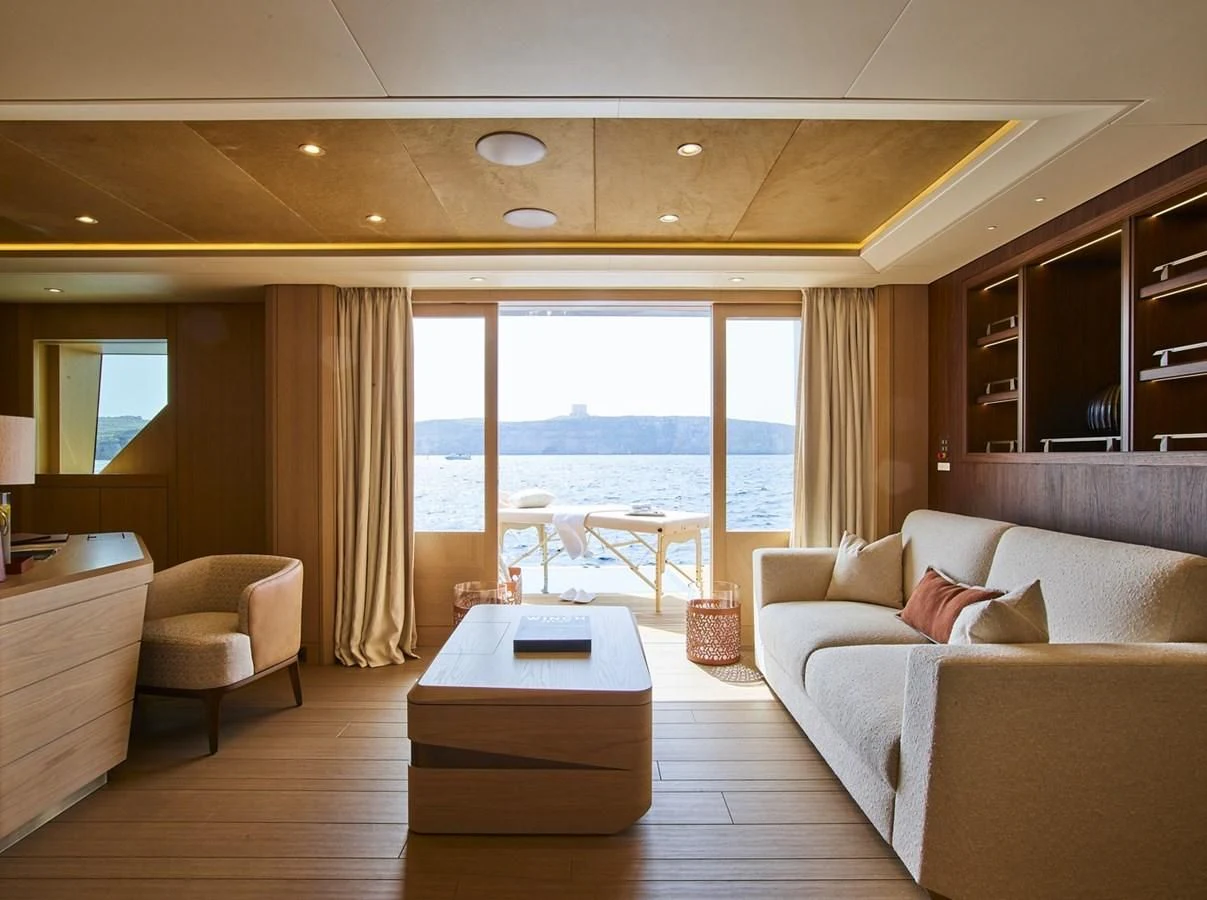 a room with a bed and a table and a window aboard COME TOGETHER Yacht for Charter