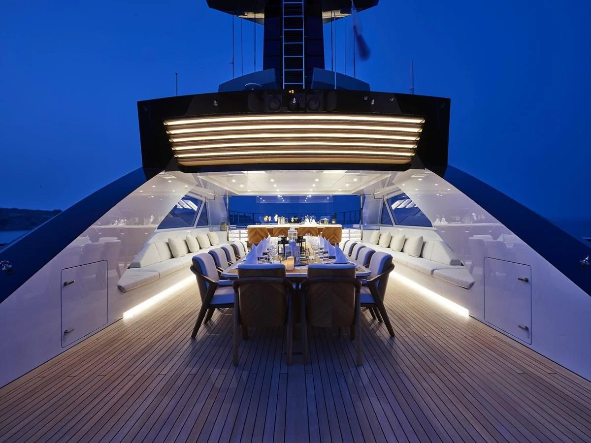 a large white boat with a table and chairs on a deck aboard COME TOGETHER Yacht for Charter