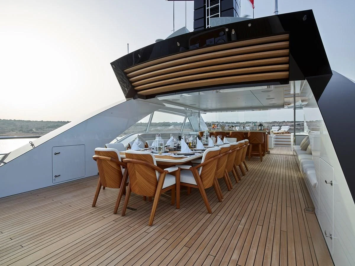 a deck with a table and chairs on it aboard COME TOGETHER Yacht for Charter