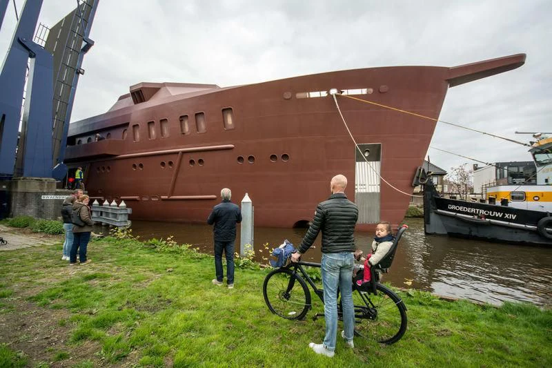 a person on a bicycle next to a boat and a large ship aboard SHERPA Yacht for Sale